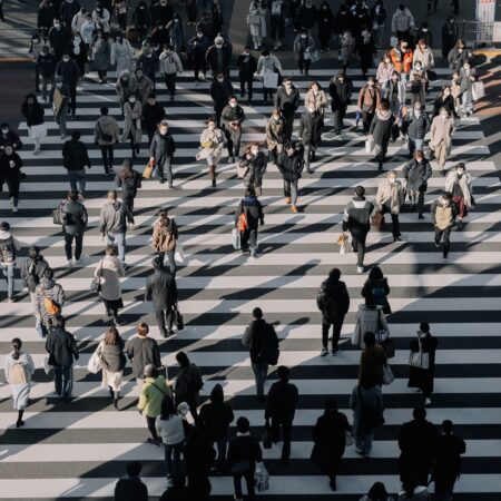 An aerial view of a crowd crossing a city street