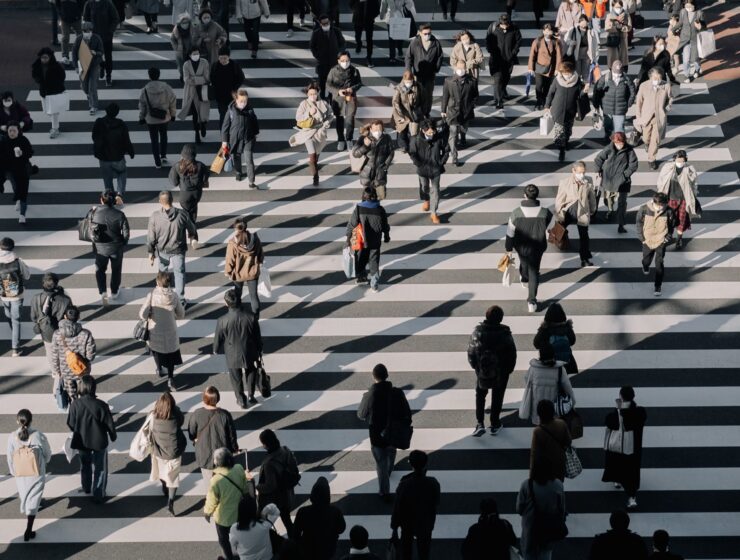 An aerial view of a crowd crossing a city street