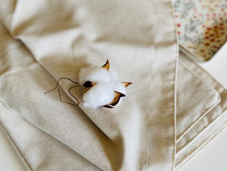 A cotton boll resting on beige linen fabric