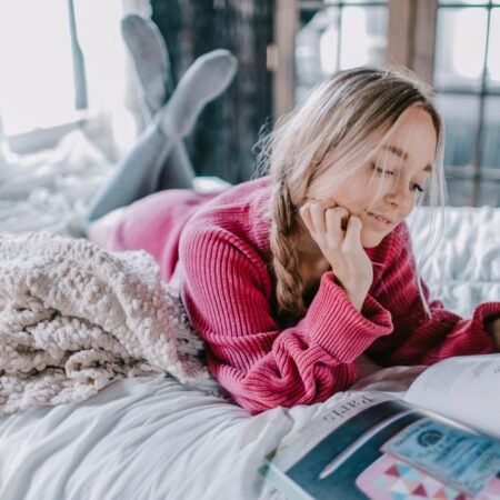 A woman reading a book on a bed