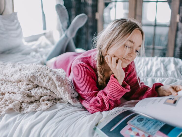 A woman reading a book on a bed